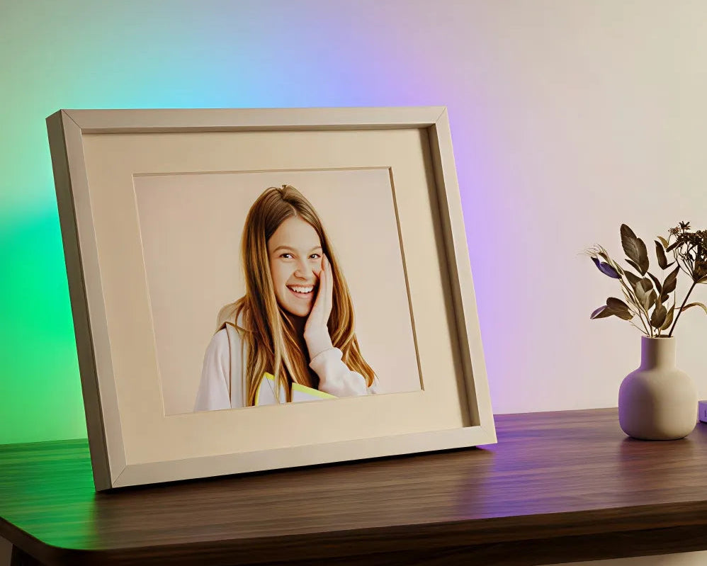 iFramix digital photo frame with integrated ambient LED lighting acting as a wall sconce, displaying a family photo with a soft, mood-enhancing glow.